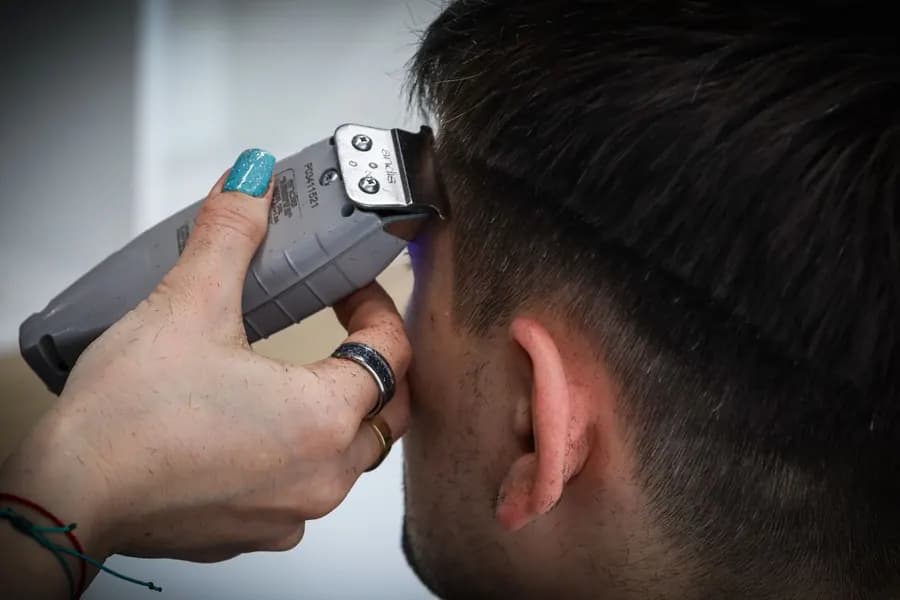 Electric clippers trimming hair in close-up