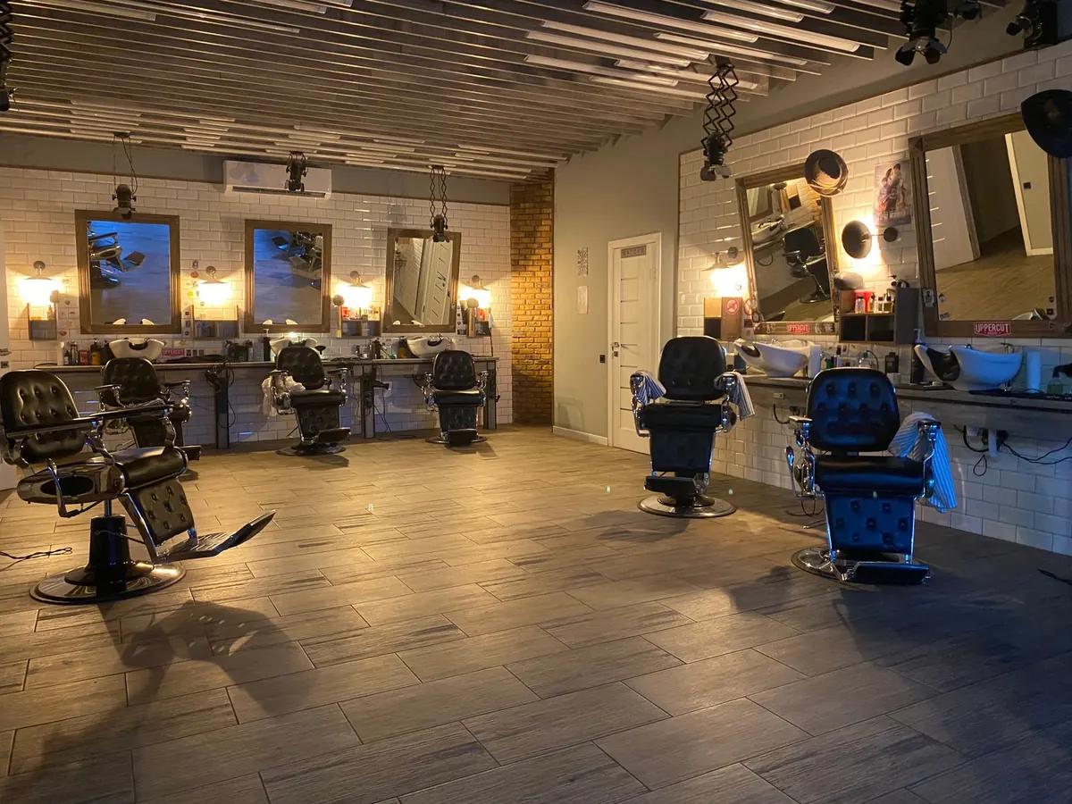 Empty barbershop with chairs, mirrors and warm lighting