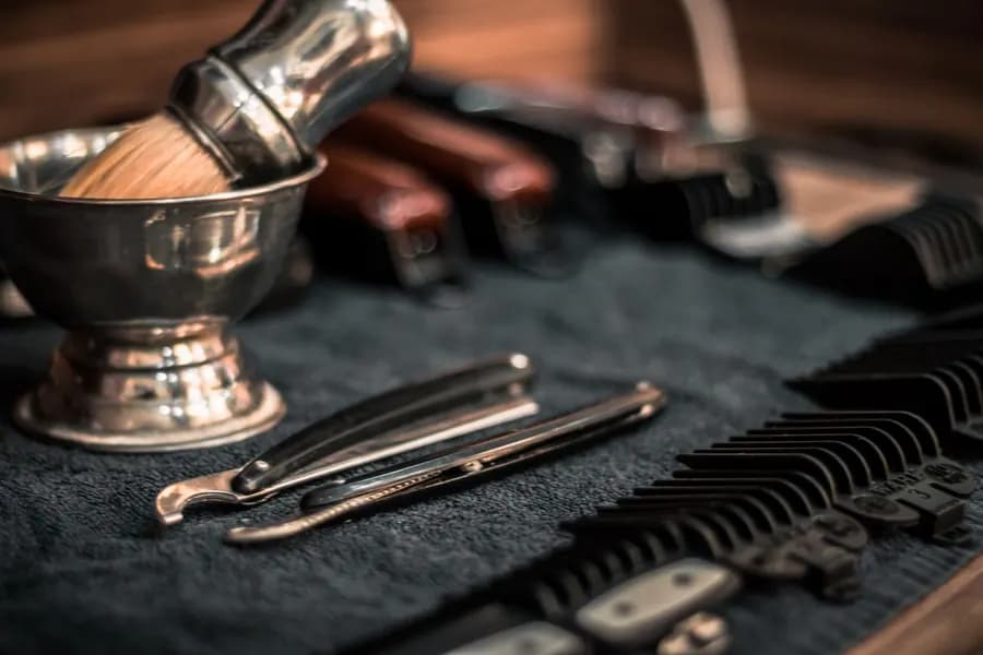 Straight razor, shaving brush and clippers on a counter