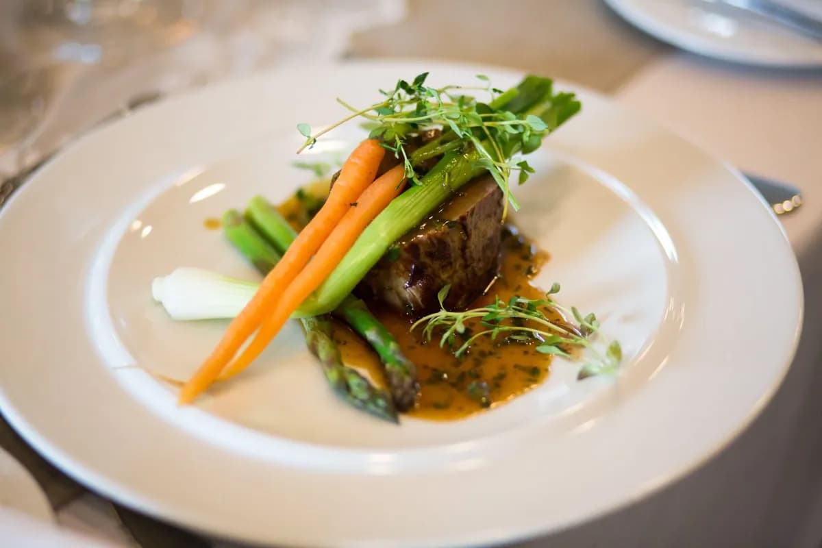 Plated slow-cooked beef with carrots and greens