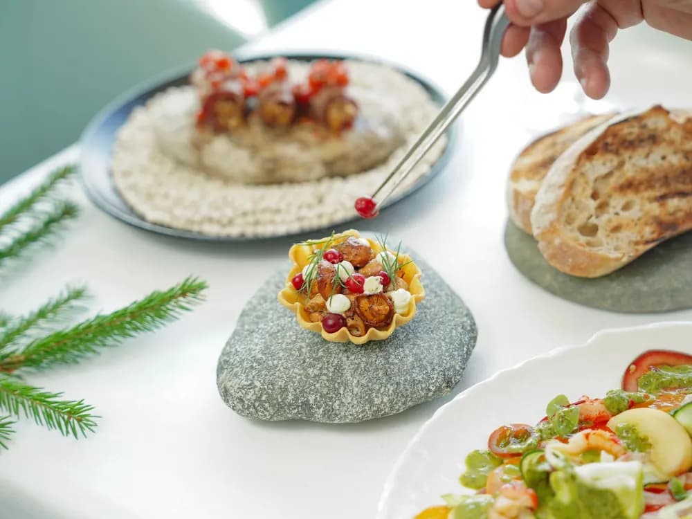 Chef garnishing small plates in a kitchen